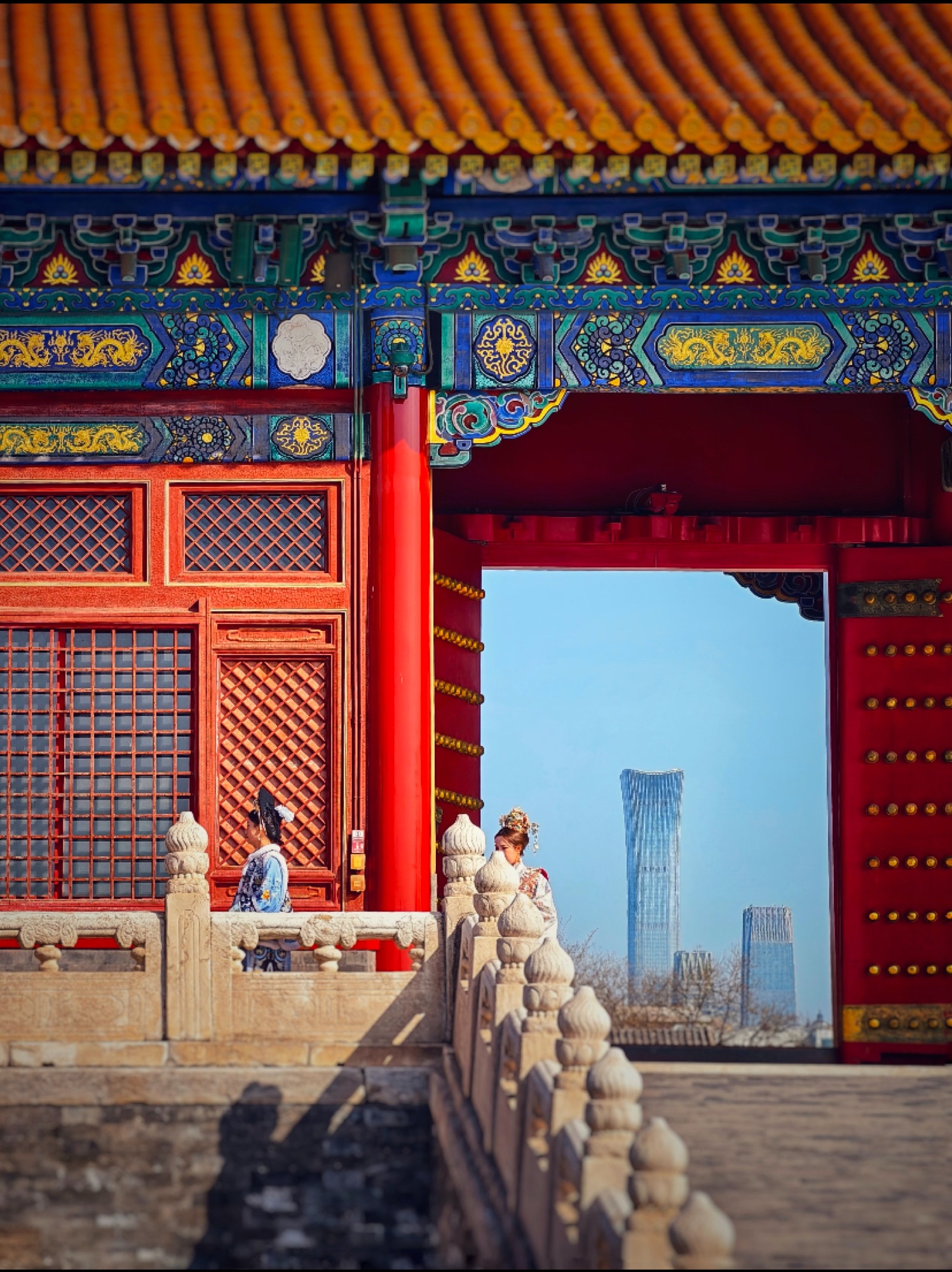 A traditional imperial gate framing a modern skyscraper